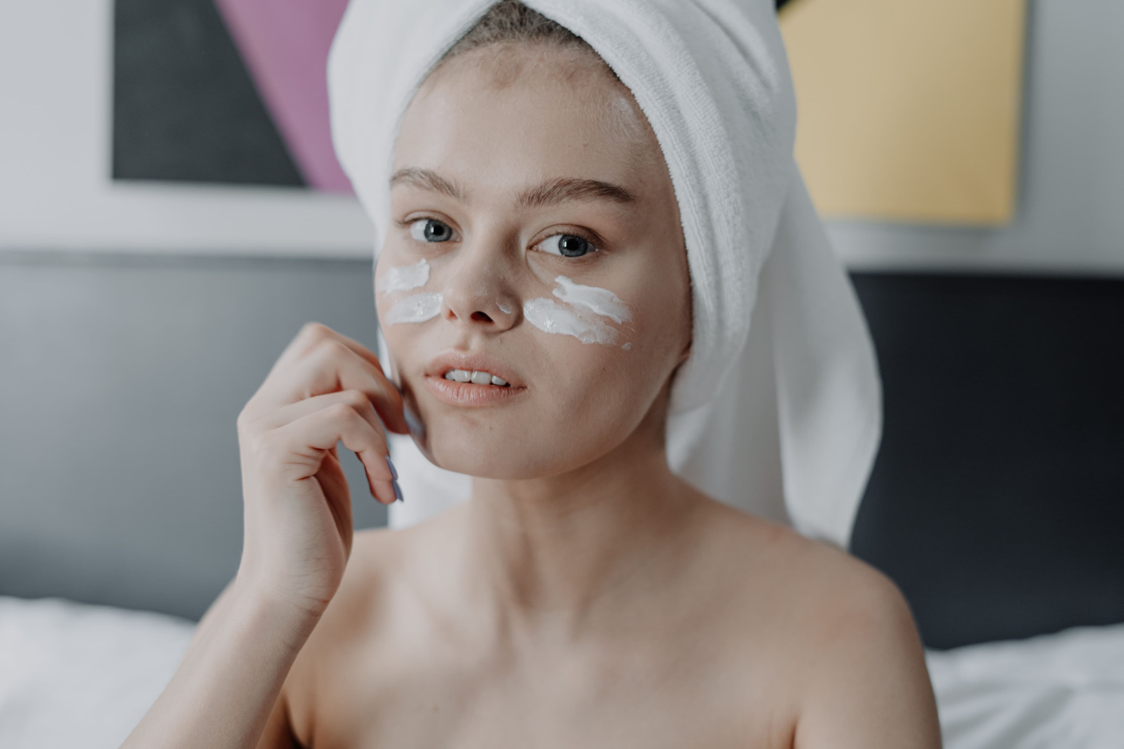 Rich winter moisturizer and facial oil next to a warm knit blanket