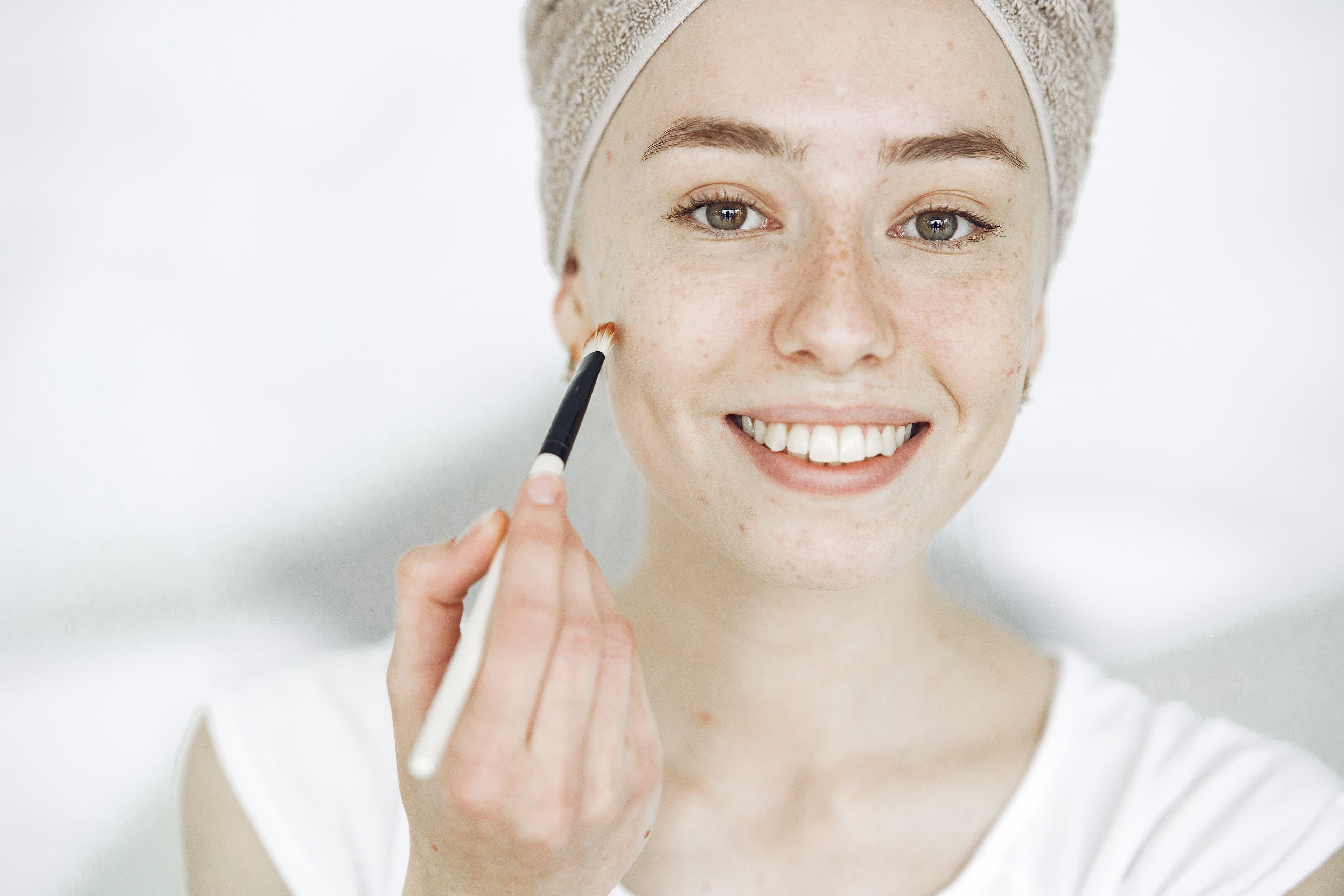 Woman applying brightening serum to even out skin tone